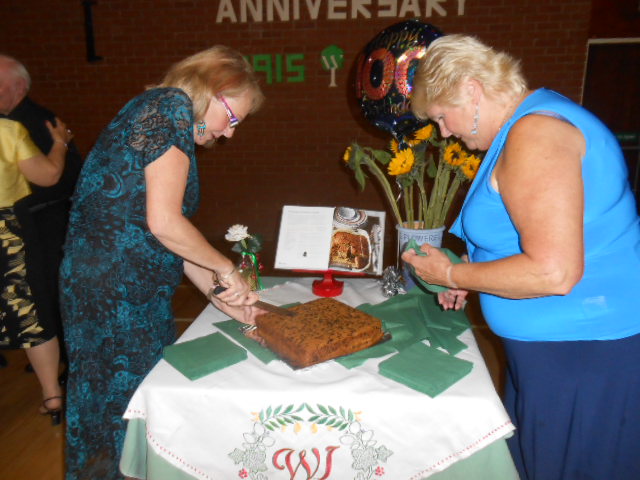 Chris Smith & Jan Middleton cutting the cake at the 100 year celebration meal